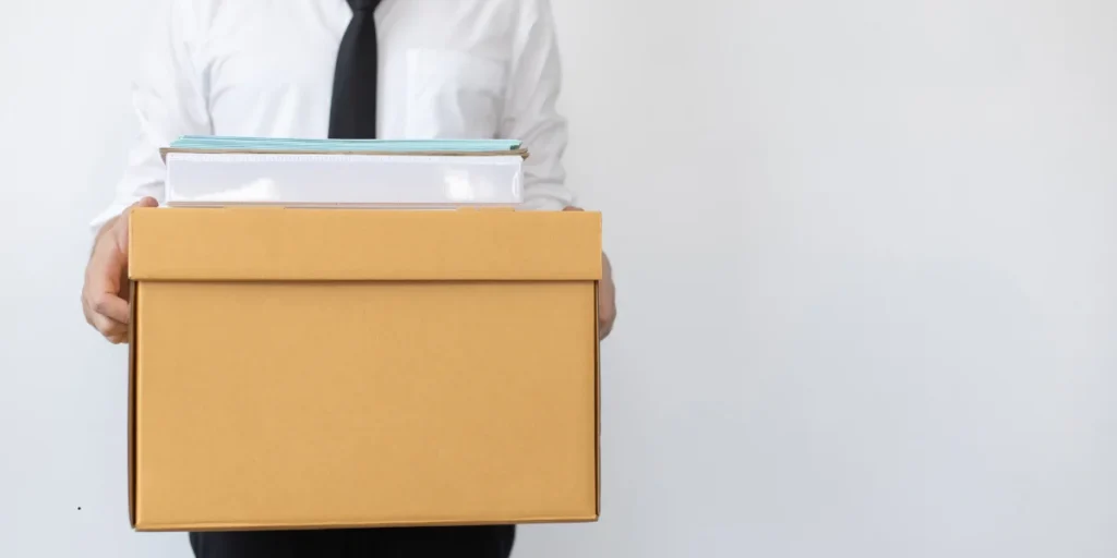 man holding box with office supplies 